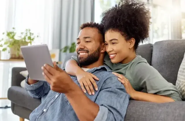 Couple viewing tablet together on the couch